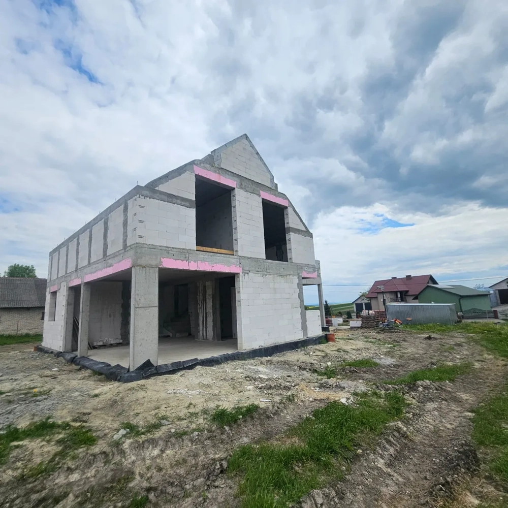 Budowa domów: murowany budynek jednorodzinny w stanie surowym otwartym na przygotowanym terenie