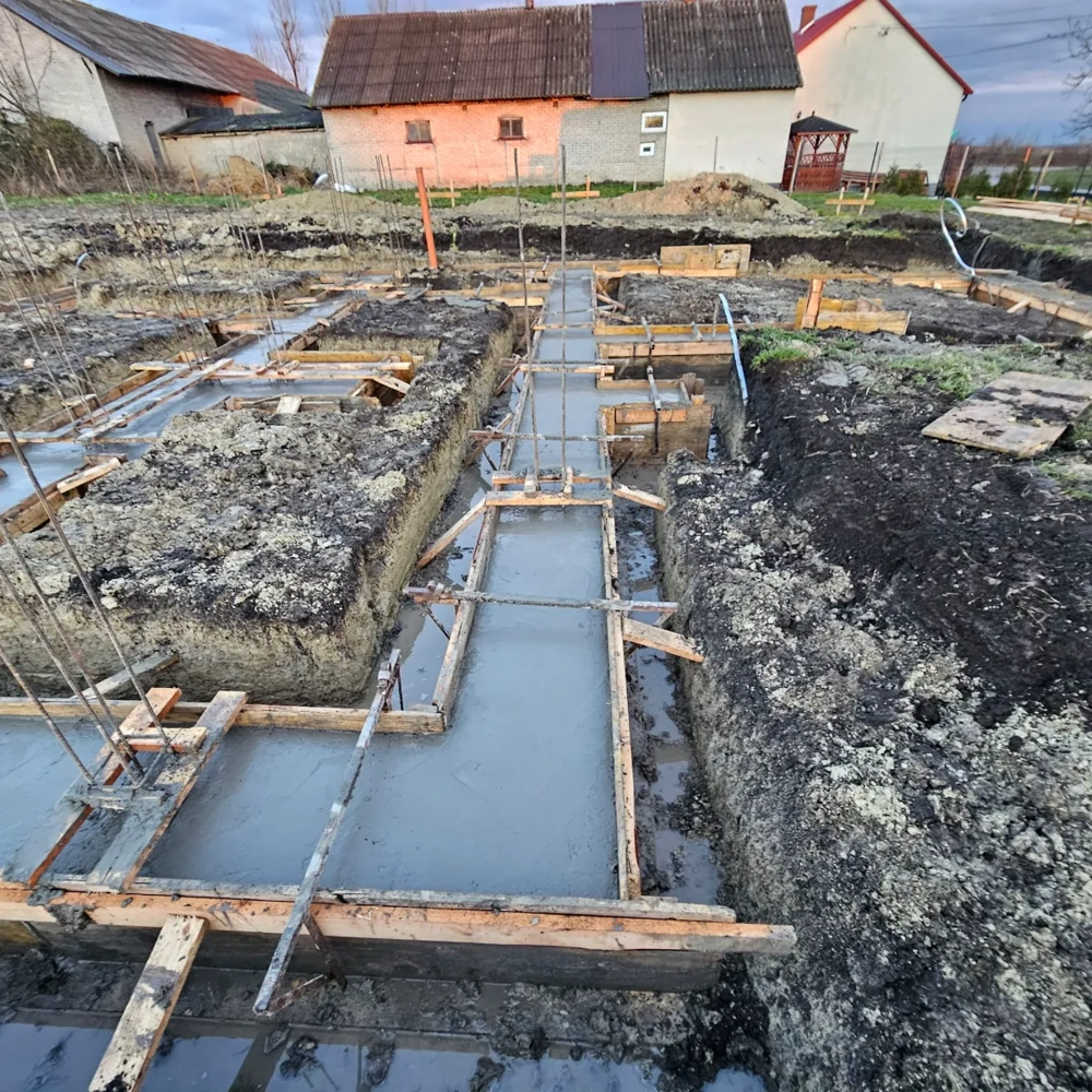 Fundamenty: beton wylewany w wykopach z drewnianą szalunkiem na przygotowanym terenie budowy