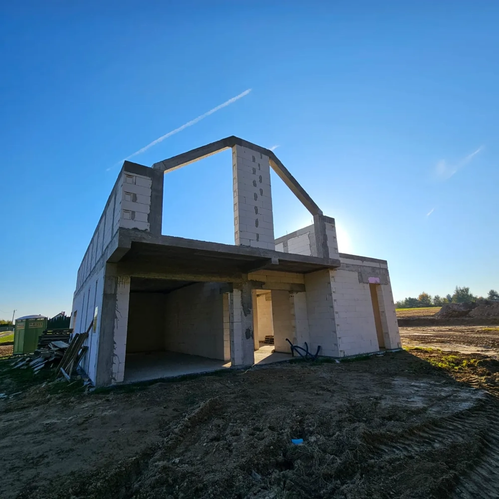 Murowana konstrukcja domu w stanie surowym na placu budowy – budowa domów