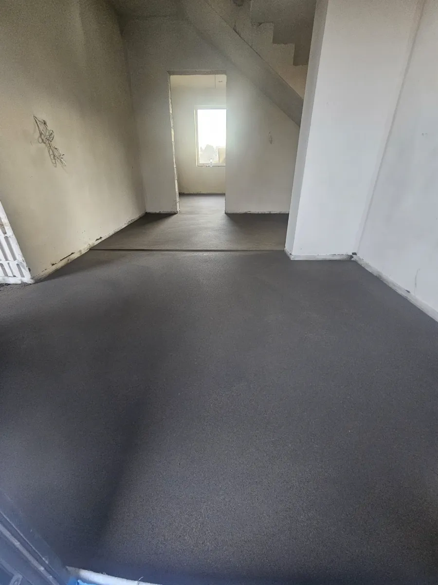 Posadzki maszynowe: gładka szara wylewka w surowym wnętrzu domu