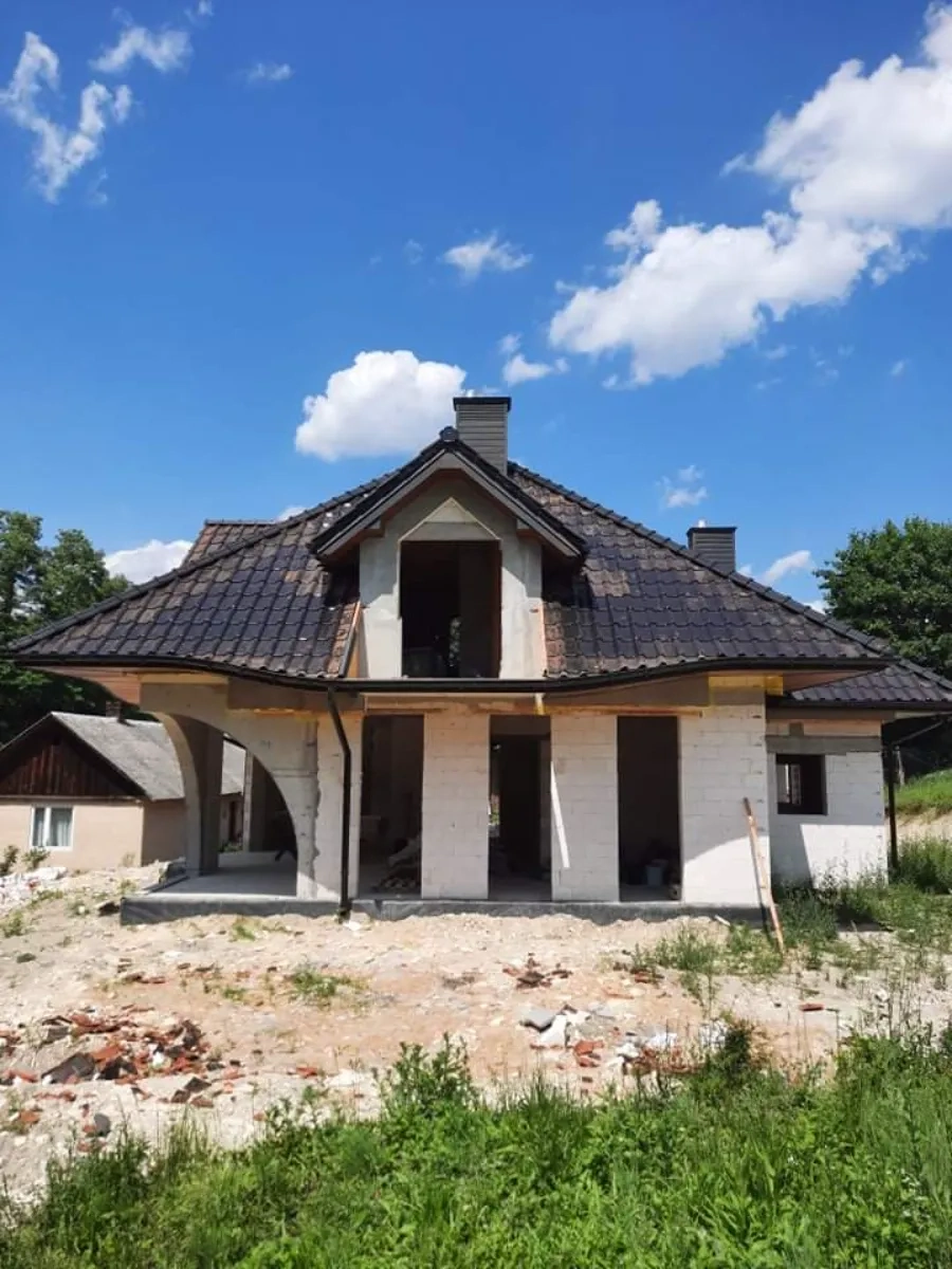 Stan surowy zamknięty domu jednorodzinnego z pokryciem dachowym i otworami okiennymi – Budowa domów