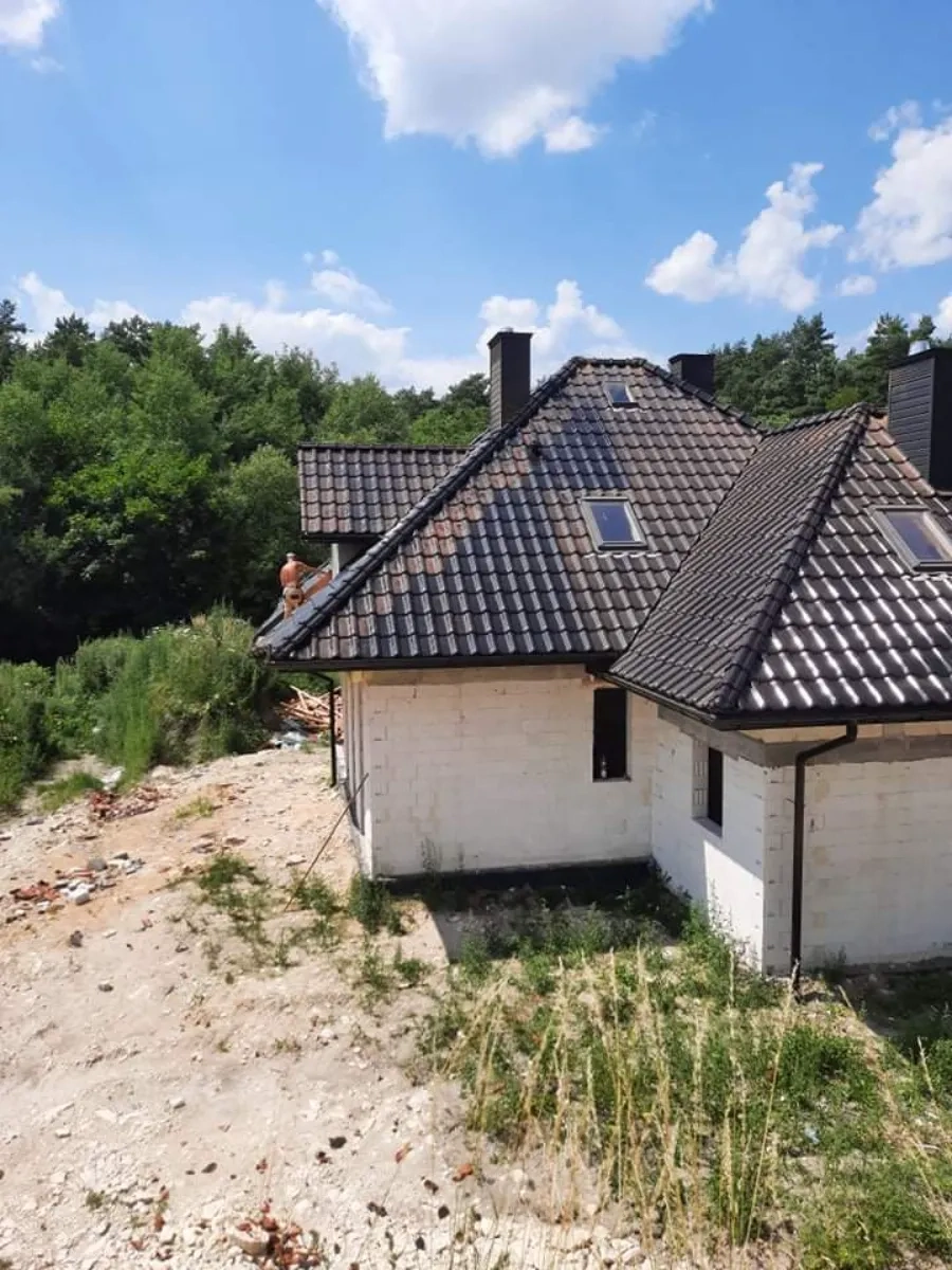 Montaż czarnej dachówki na dachu murowanego domu w stanie surowym - Dach